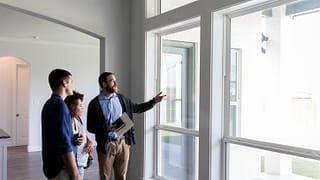 realtor with couple in house KoSQxI.width .jpg