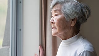 senior woman looking outside care facility.jpg