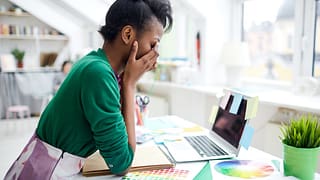 stressed young woman sitting at desk in front.width XQyxeQY.jpg