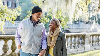 two older people walking in the park holding handds.jpg