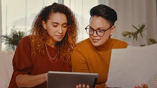 two people looking at tablet and paperwork aL.width .jpg