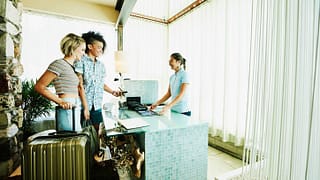 two women checking into hotel VFnxxdU.width .jpg
