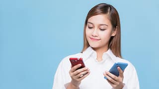 woman looking at red phone and blue phone.width .jpg