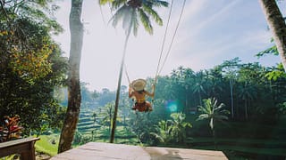 woman on swing in tropical vacation.width .jpg