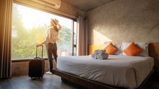 woman with suticase at hotel room window.width .jpg