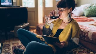 woman with wine watching movie on tablet.width .jpg