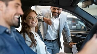 Car salesman assisting coupe with car purchas.width aDiU.jpg