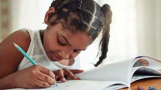 Child coloring in activity book. LGCfO.width .jpg
