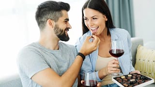 Couple eating chocolates and drinking wine to.width .jpg