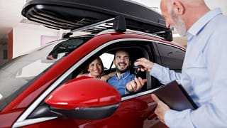 Couple receiving a new car keys from car sale.width PKhkAs.jpg