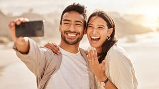 Couple smiling and taking selfie with engagem.width .jpg