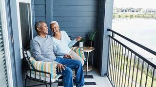 Happy mature couple sitting on balcony overlo.width gFthua.jpg