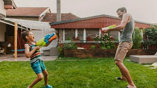 Man and child play with squirt guns in homes .width qPwAKO.jpg