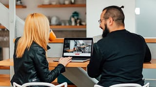 Man and woman look at homes on a laptop ezCl.width .jpg