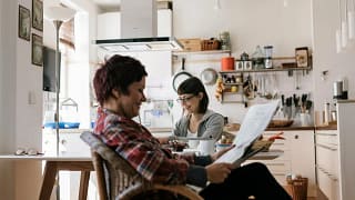 Two people in a kitchen reading the news toJ.width .jpg