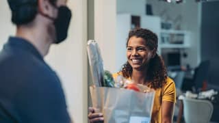 Woman accepting a delivery of groceries. EZB.width .jpg