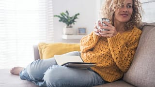 Woman drinking coffee on couch GTFVC.width .jpg