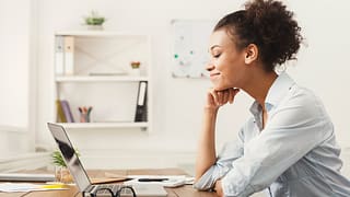 Woman smiling at office desk SulIyMb.width .jpg