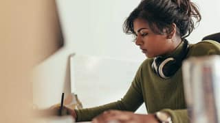 Young woman writing with headphones rJQSmvR.width .jpg