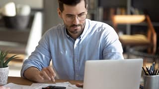 a person with a laptop calculator and documents in front of them gettyimages .jpg