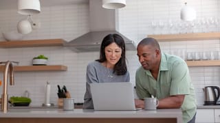 couple staring at computer in kitchen.jpg