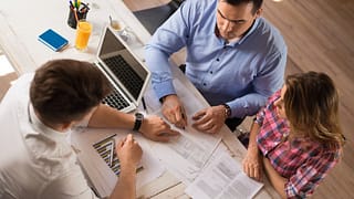 man and woman sitting across desk from man in.width dKyola.jpg