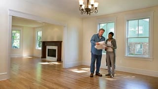 man and woman with blueprints in empty house .width .jpg