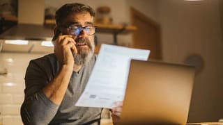 man on phone with paper and laptop KarxXs.width .jpg