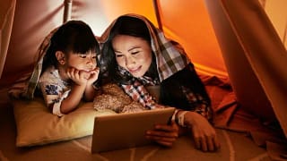 mom and young daughter watching movie on tabl.width .jpg