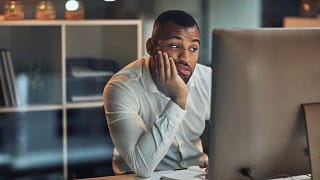 person sitting at a computer looking uncertain.jpg