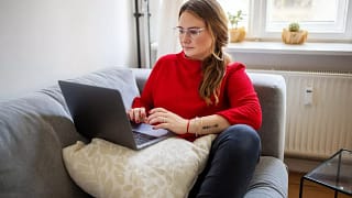 person on couch with laptop NhPfiGo.width .jpg