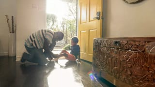 person putting on childs shoes at front door .width hxnClq.jpg