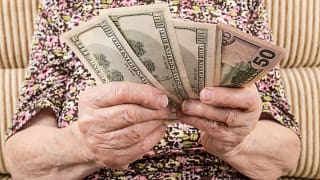senior woman holding cash money bills social security cola retirement getty.jpg
