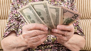 senior woman holding cash money bills social security cola retirement getty.jpg