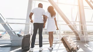 two people with suitcases holding hands hNDS.width .jpg