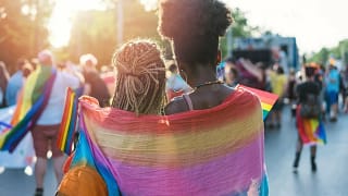 two women in rainbow flag at parade.width .jpg