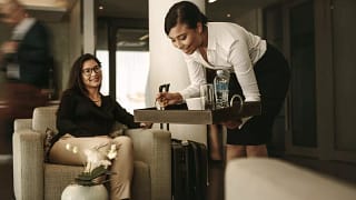 waitress and customer in airport lounge fc.width .jpg