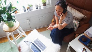 woman on phone with credit card and laptop y.width .jpg