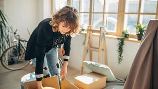 woman packing moving boxes in apartment Pedi.width .jpg