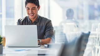 young man s a smiling person at a laptop gettyimages .jpg