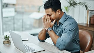 young man stressed laptop a person at a laptop putting their hands on their face and closing their eyes gettyimages .jpg