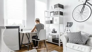 young woman at desk in small apartment.width .jpg