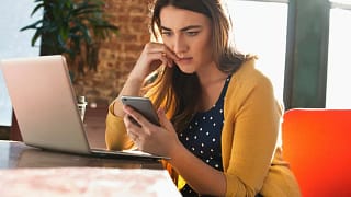 Woman using cell phone with concerned look on.width UczVhr.jpg