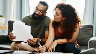 couple with bills signing papers.width .jpg
