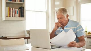 stressed person with papers and laptop UsCv.width .jpg