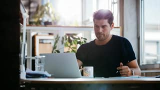 young man sitting at desk using laptop and th.width rNXRoV.jpg