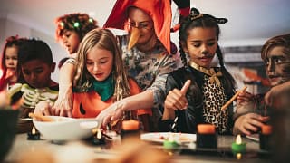 Adults and kids doing crafts at a halloween p.width .jpg