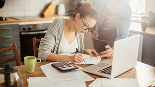 Woman with glasses making calculations VoscoL.width .jpg