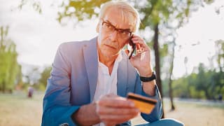 older man upset on phone holding credit card .width NRkzbw.jpg