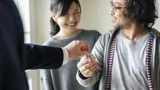 realtor handing couple house keys.width .jpg